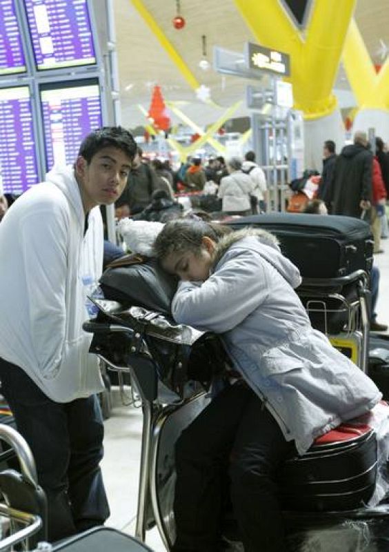 Otros pasajeros tratan de descansar mientras esperan la salida de su avión.  
