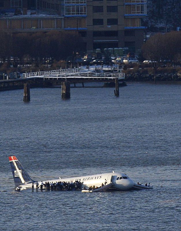 Los pasajeros del avión esperan en las alas del avión siniestrado que un ferry les rescate.