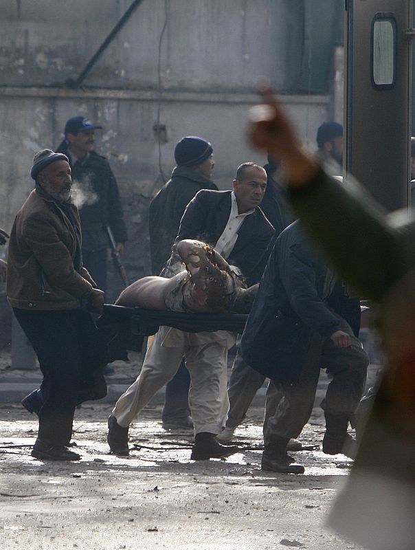 People carry a victim of a blast at the German embassy in Kabul