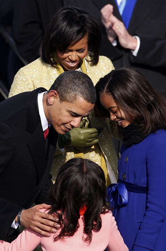 U.S. President Barack Obama leans in to kiss daughter Sasha after he is sworn-in as 44th President of the United States in Washington