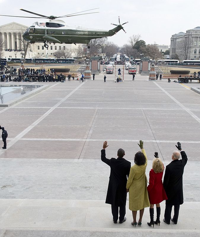 El presidente Obama y el vicepresidente Biden, junto a sus esposas, despiden al helicóptero presidencial en el que George W. Bush y su mujer han abandonado Washington.