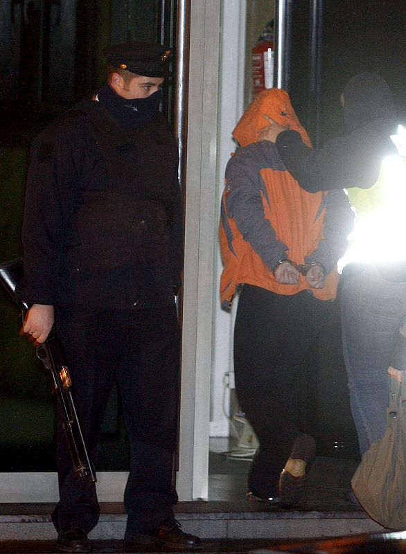 Agentes de la Policía Nacional conducen a uno de los detenidos esta madrugada a la comisaría de San Sebastián, en el marco de la operación dirigida por el juez de la Audiencia Nacional Baltasar Garzón.