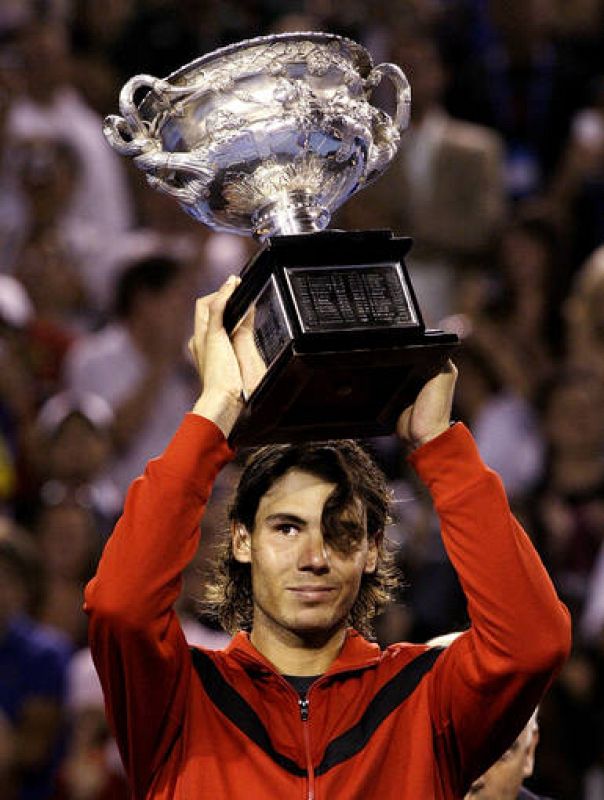 Spain's Nadal holds up the trophy after winning his men's singles final match against Switzerland's Federer at the Australian Open 