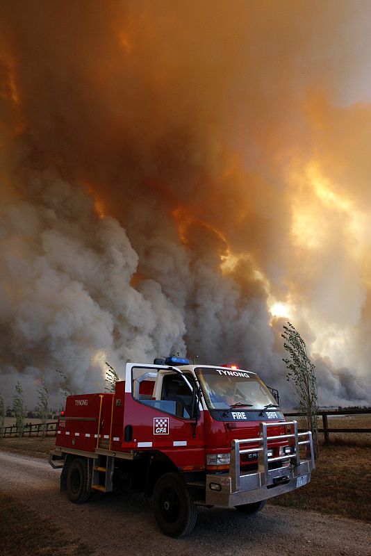 A fire truck is seen as a bushfire approaches the town of Labertouche