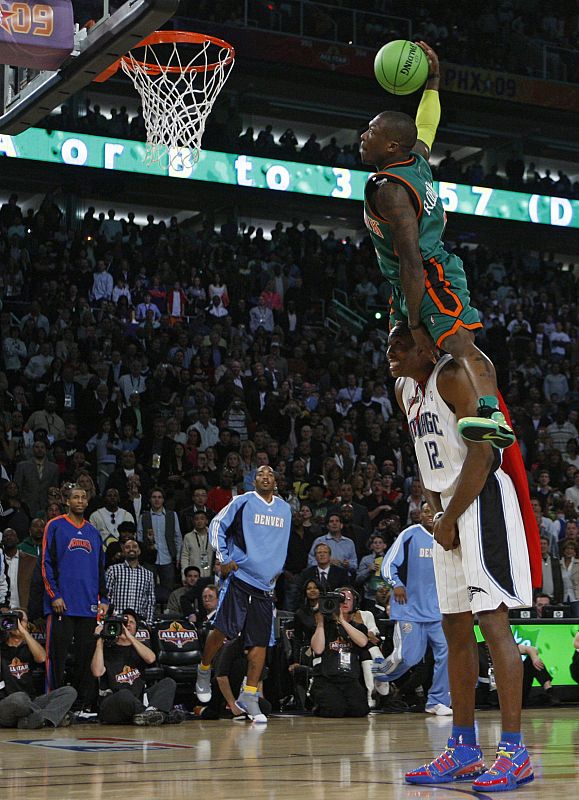 Knicks' Robinson leaps over Magic's Howard while competing in the Slam Dunk contest at NBA All-Star weekend in Phoenix