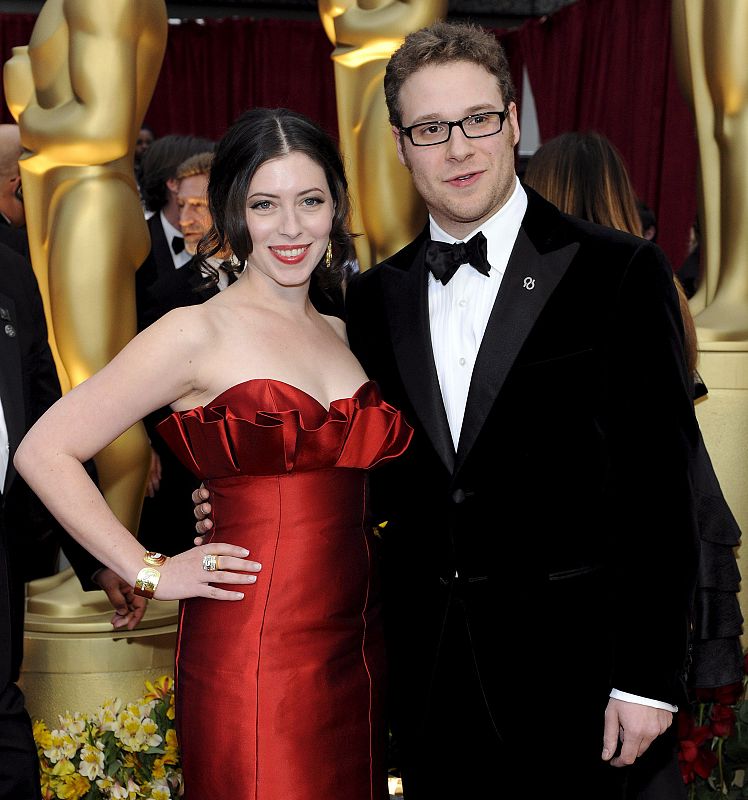 El actor estadounidense Seth Rogan y su acompañante posan sobre la alfombra roja.