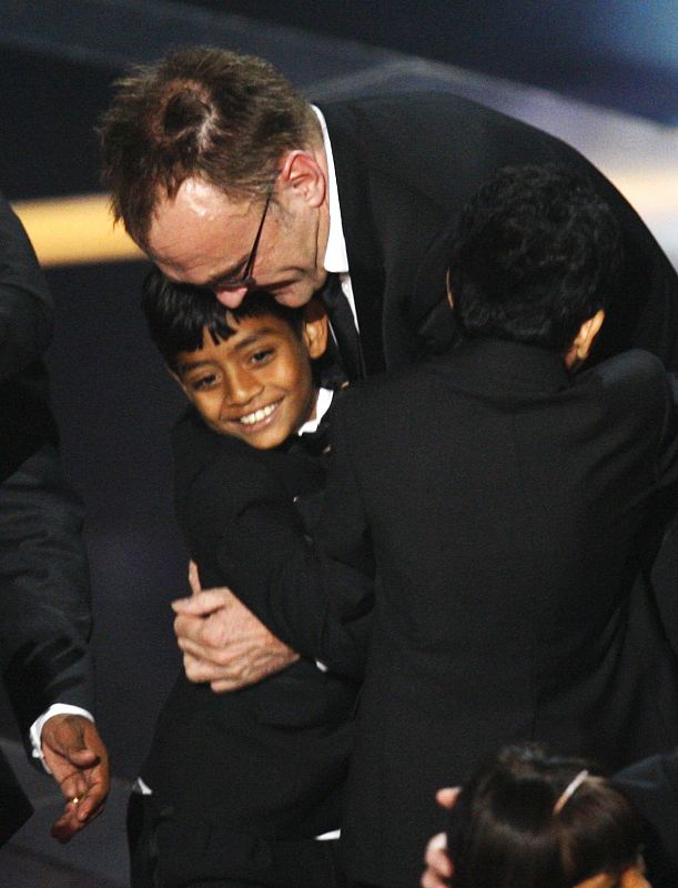 Director Boyle celebrates with actors Ismail and Mahesh after "Slumdog Millionaire" won Oscar for best picture in Hollywood