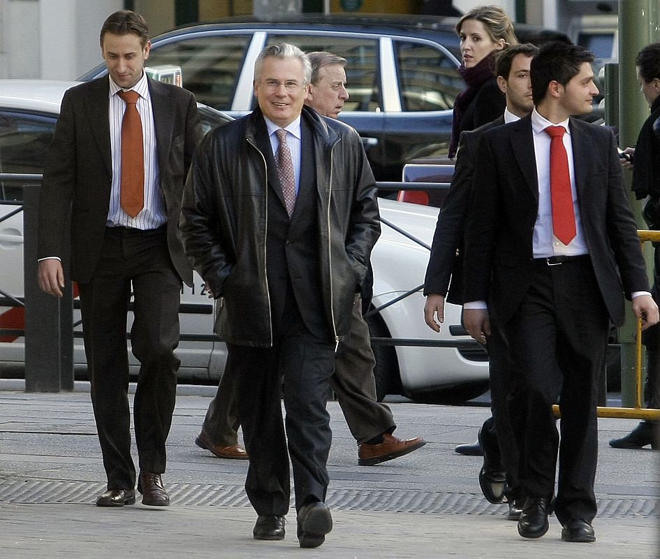 High Court magistrate Garzon walks with plainclothes police officers towards the entrance of the High Court in Madrid