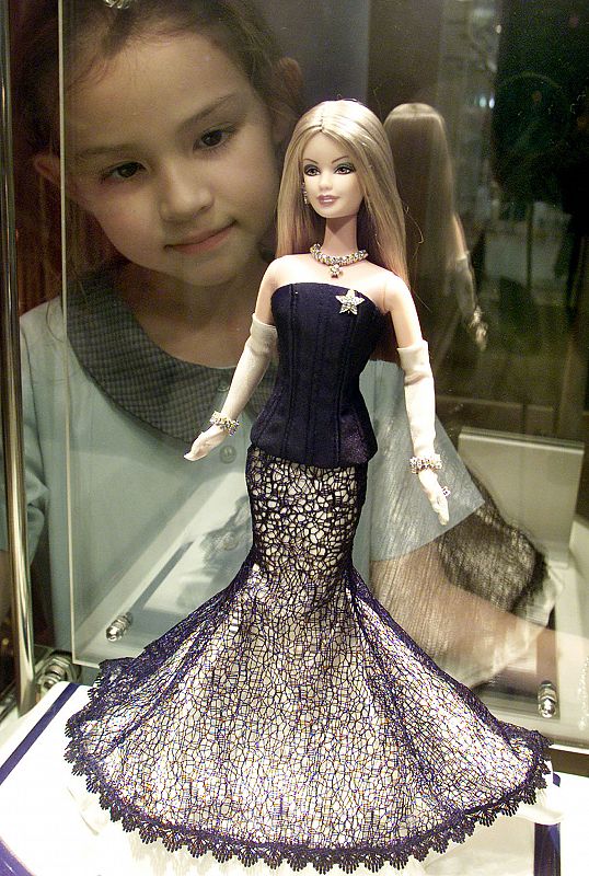 Barbie 50 años: Una niña mira una muñeca con diamantes, en Bangkok