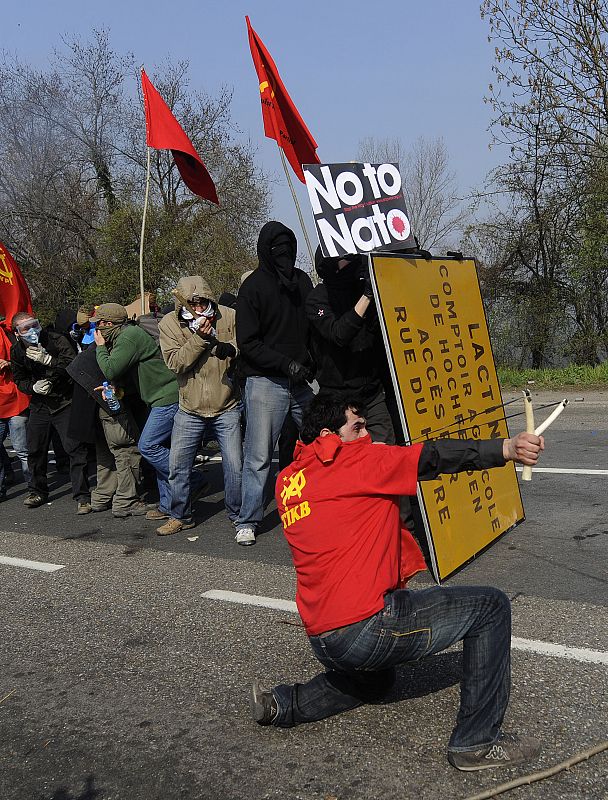 Anti-NATO protestors throw stones and use sling shots towards French police during a rally against the NATO summit in Strasbourg