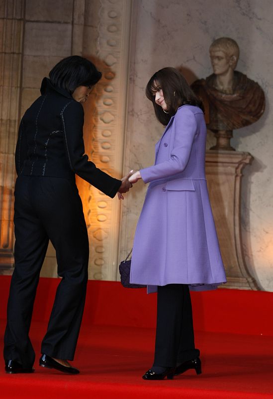 France's first lady Carla Bruni-Sarkozy and U.S. first lady Michelle Obama hold hands as they arrive for the visit of the Strasbourg's Cathedral