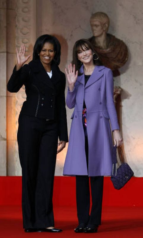 France's first lady Carla Bruni-Sarkozy and U.S. first lady Michelle Obama wave as they arrive for the visit of the Strasbourg's Cathedral 
