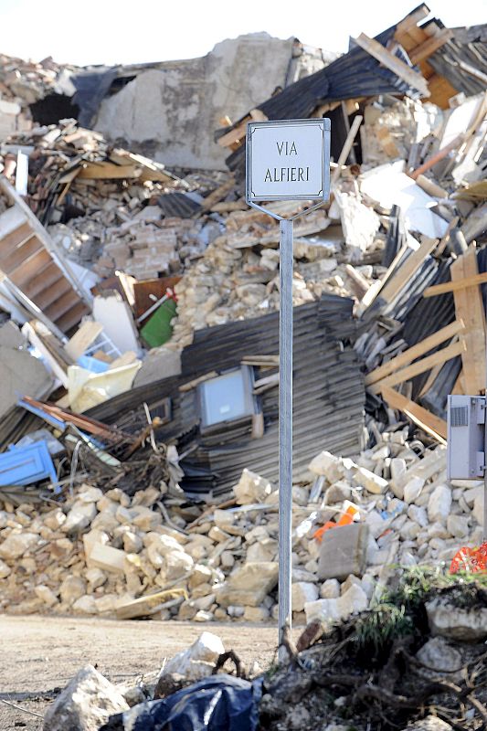 La señal de una calle de Onna  es la única cosa que se mantiene en pie en una vía llena de escombros.