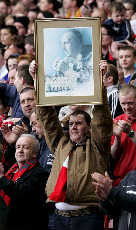 Un seguidor del Liverpool sujeta una foto del ex manager del Liverpool, Bill Shankly.