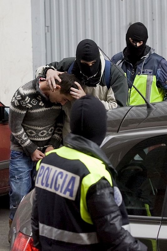 Miembros de la Policía Nacional conducen a uno de los detenidos en su domicilio en la calle Isanza de la capital alavesa.