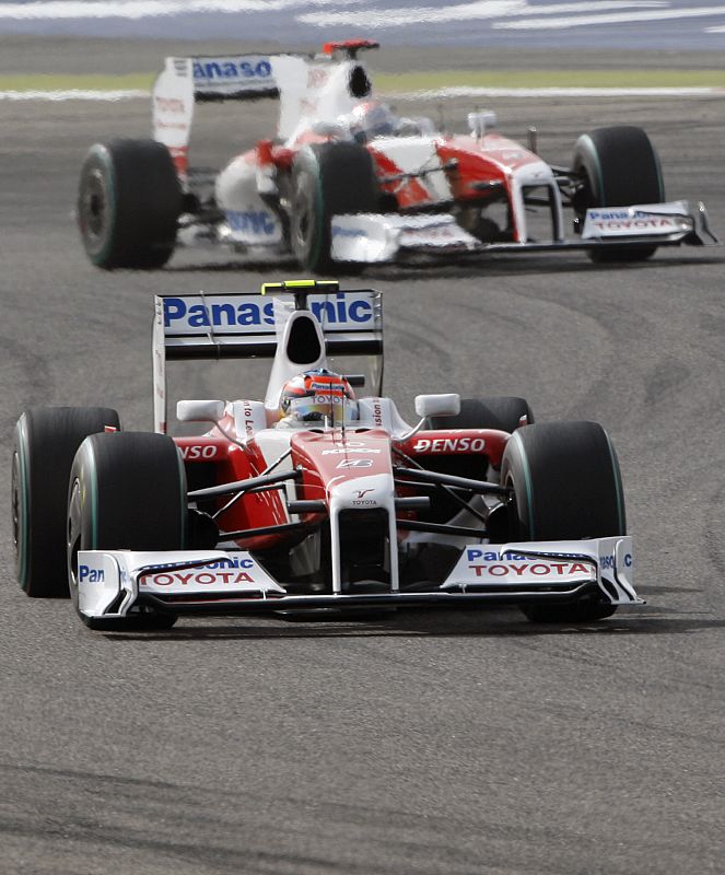 El italiano Jarno Trulli aceha a su compañero de equipo Timo Glock.