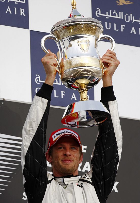 El piloto de Brawn GP, Jenson Button, levanta el trofeo en el podio del Gran Premio de Bahrein.