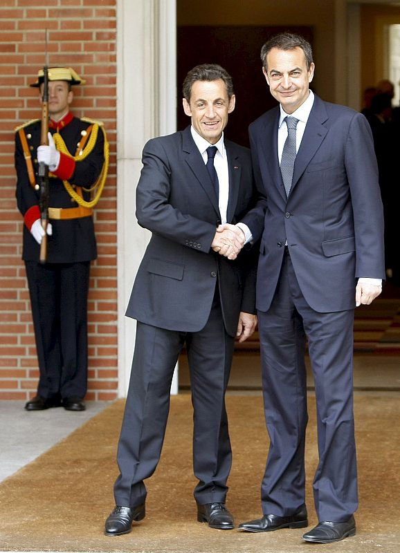 El presidente del Gobierno, José Luis Rodríguez Zapatero, y el presidente francés, Nicolas Sarkozy, se dan la mano a la puerta de La Moncloa.