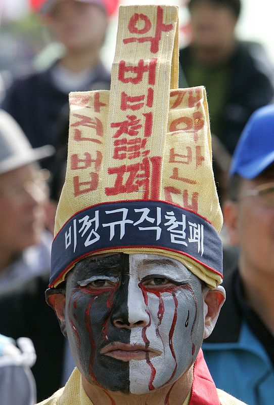 Unionised worker wearing mourning clothes takes part in May Day rally denouncing Lee government's economic policies in Seoul