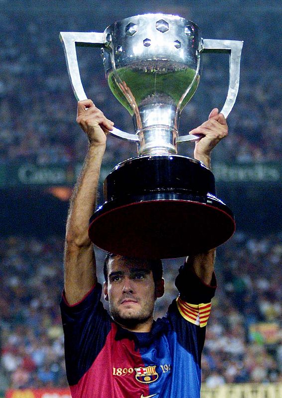 BARCELONA'S CAPTAIN JOSEP GUARDIOLA RAISES THE TROPHY.