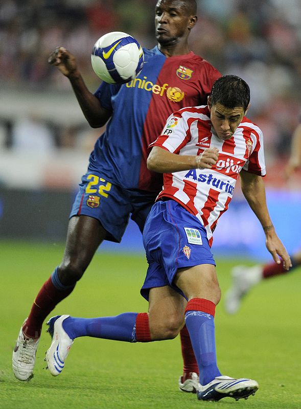 Barcelona's Abidal is challenged by Sporting Gijon's Maldonado during their Spanish first division match in Gijon