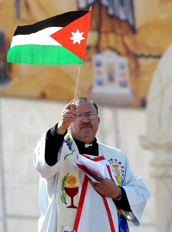 Un sacerdote ondea una bandera de Jordania durante la misa de Benedicto XVI.