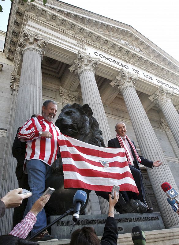 Los diputados del PNV Josu Erkoreka (d) y Pedro Azpiazu colocaron los colores del Athletic de Bilbao a uno de los emblemáticos leones del Congreso