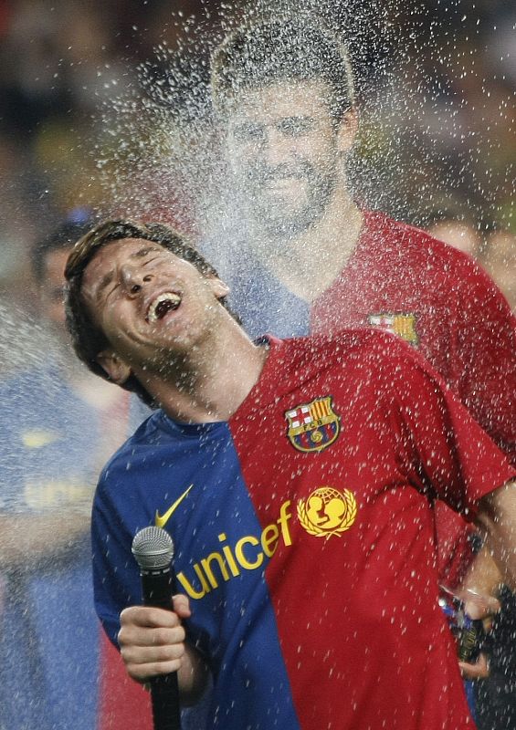 Barcelona's Pique sprays champagne on Messi during celebrations of their Spanish first division soccer league trophy in Barcelona