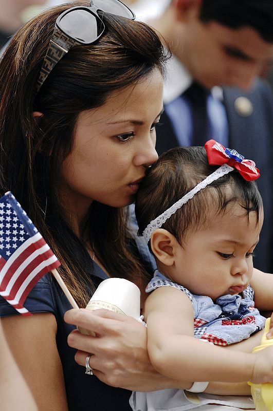 Una madre besa a su bebé durante la oración que cierra el discurso de Obama