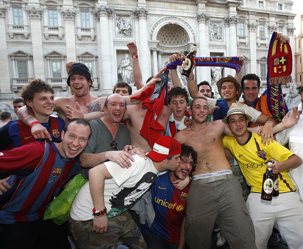 Un grupo mixto de aficionados de ambos equipos posa frente a la Fontana de Trevi