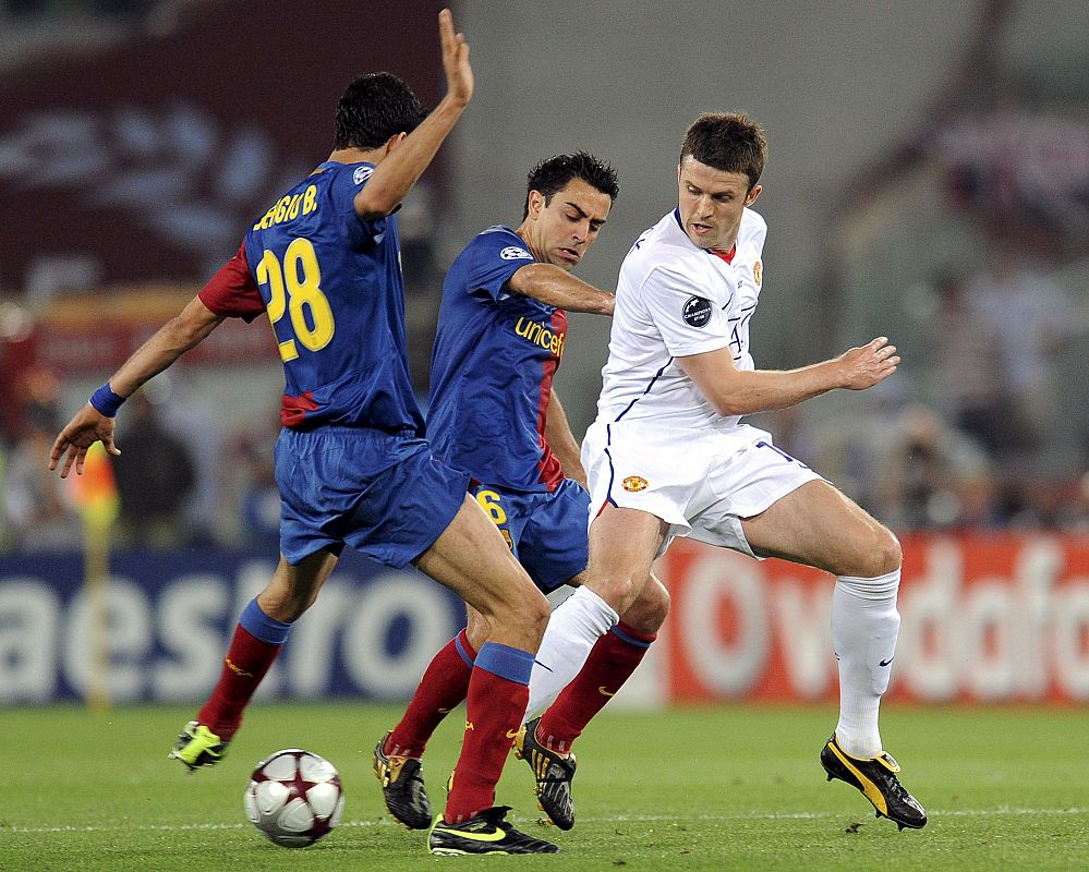 Michael Carrick lucha por el balón con Sergio Busquets.