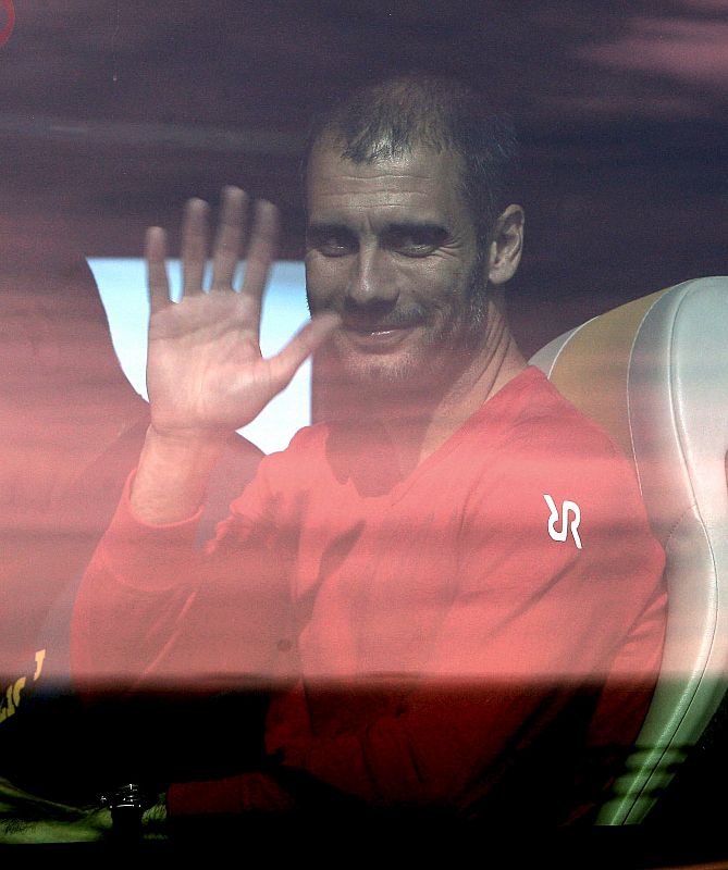 Pep Guardiola saluda desde el autobús a su llegada al aeropuerto de Prat.