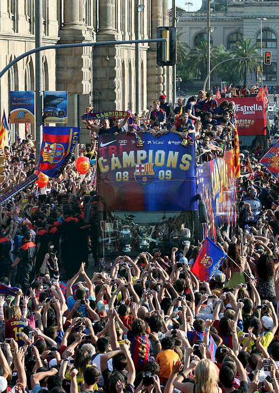 Miles de aficionados del FC Barcelona se concentran a lo largo del recorrido del autocar.