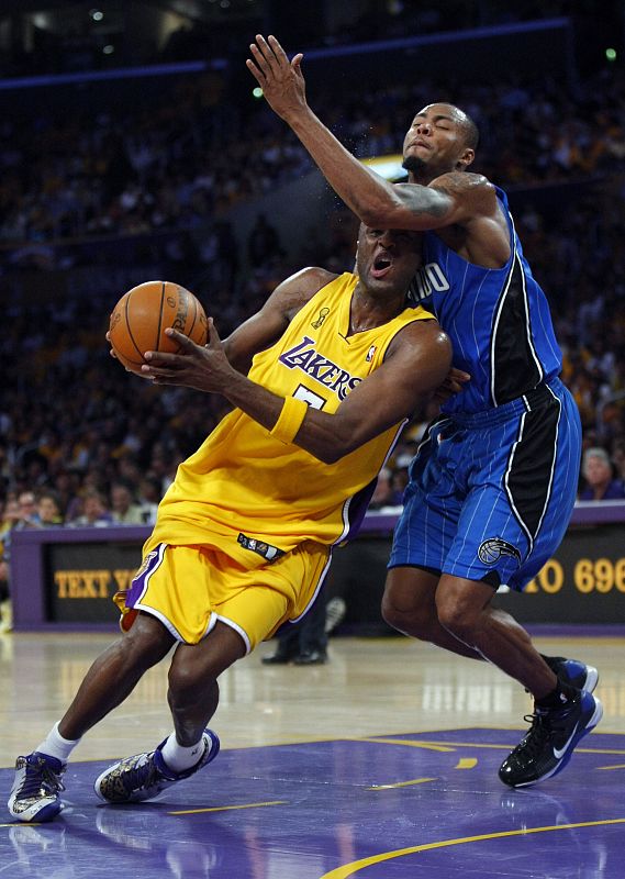 El jugador de los Ángeles Lakers, Odom, trata de llegar al aro defendido por Lewis, de los Orlando Magic durante el primer partido de la final de la NBA.