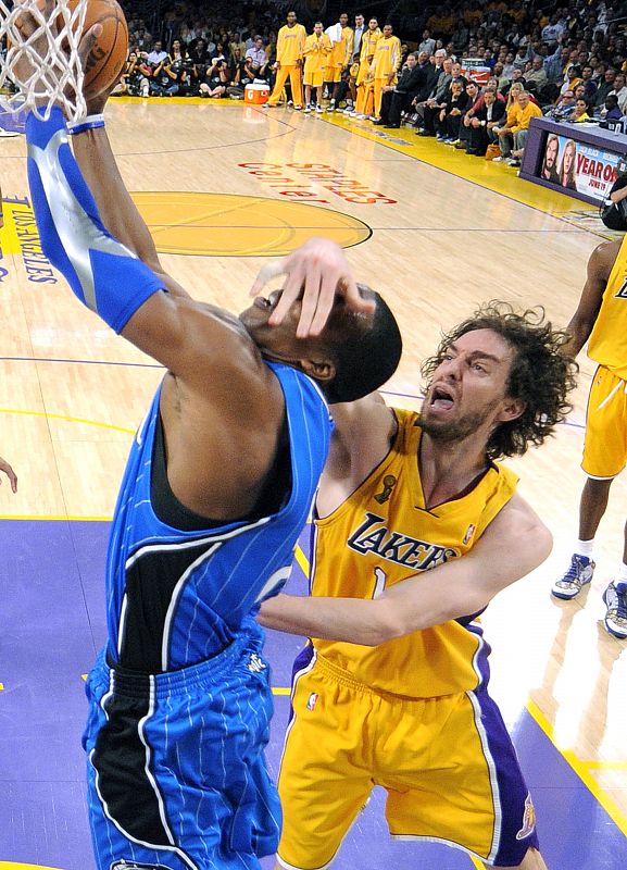 Dwight Howard de los Orlando Magic intenta encestar mientras recibe una falta de Pau Gasol, jugador de Los Angeles Lakers.