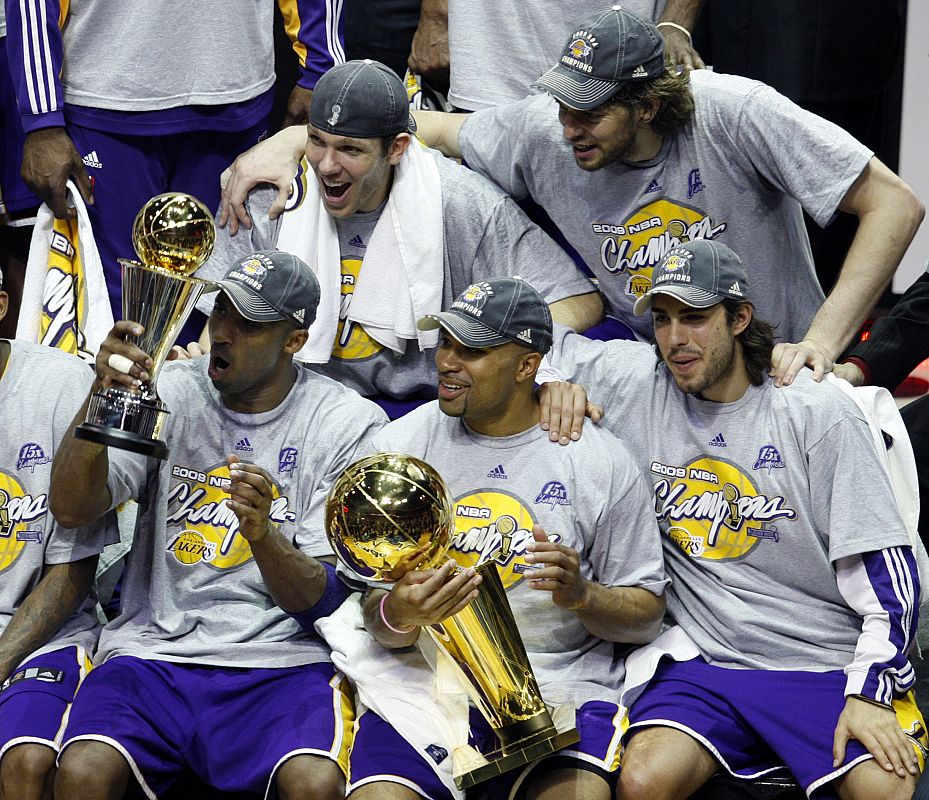 Kobe Bryant muestra la copa de campeones a sus compañeros en la foto de grupo del equipo vencedor.