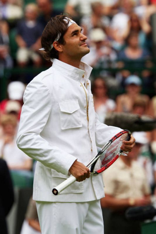 Federer en la pista central de Wimbledon con su nuevo vestuario. Sobresale la americana con cuello mao mientras sujeta la raqueta.