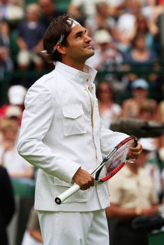  Federer en la pista central de Wimbledon con su nuevo vestuario. Sobresale la americana con cuello mao mientras sujeta la raqueta.