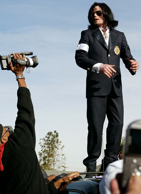 Michael Jackson saluda sobre su coche a la multitud de fans que le esperan a las puertas de los juzgados de Santa María en 2004.