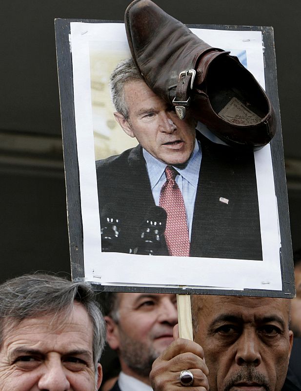 A protester displays a shoe and a picture of U.S. President George W. Bush during a protest in Amman