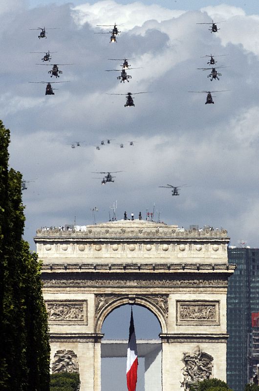 A formation of military helicopters fly over the Champs Elysees during Bastille Day in Paris