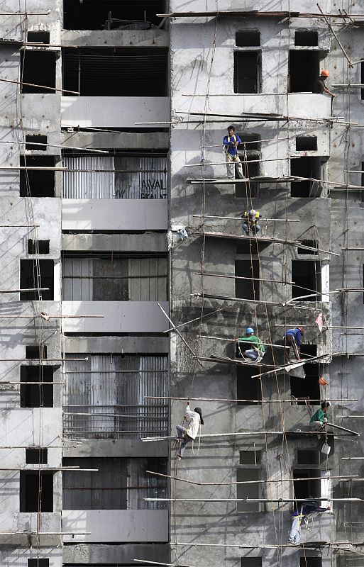 Workers climb the scaffolding at a residential construction site in Metro Manila