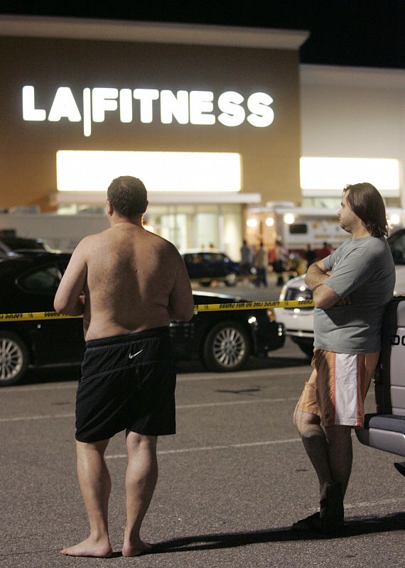 Men wait behind police lines outside the LA Fitness gym in Bridgeville