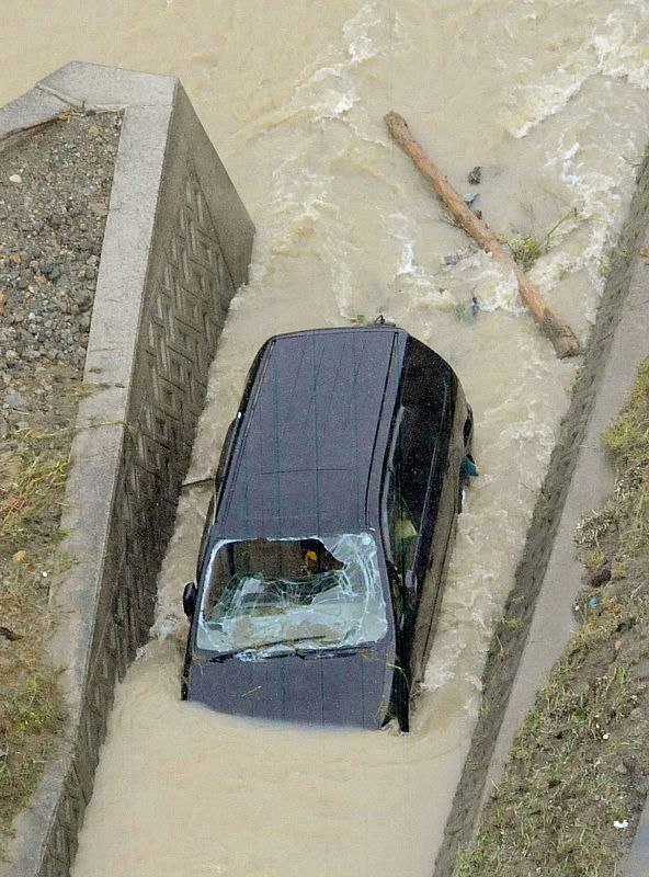 A car washed away by floodwaters is pictured in Sayo