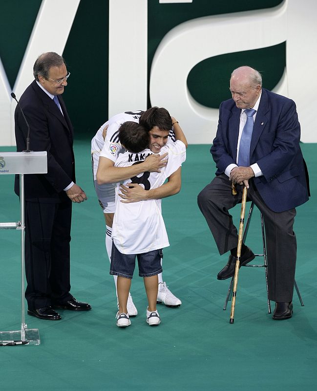 Kaká junto a Di Estéfano y Florentino durante su presentación en el Bernabéu abrazando a un niño.