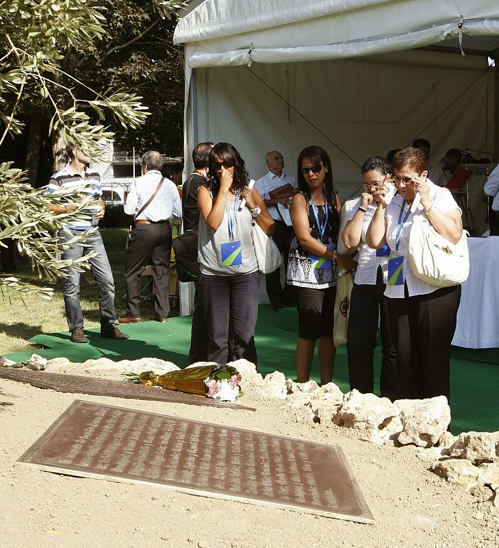 Algunos de los familiares miran la placa conmemorativa por las víctimas