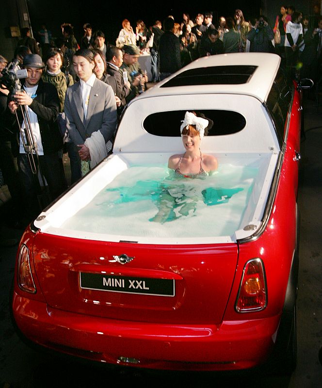 A model wearing a bikini soaks in a jacuzzi on the rear end of a limousine named "Mini XXL" at the J..