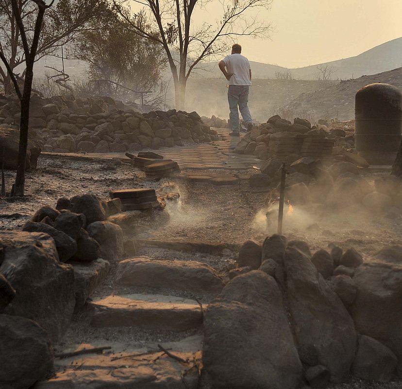 Un hombre regresa a su casa por primera vez después de que el fuego arrasase la zona de Acton, en California.