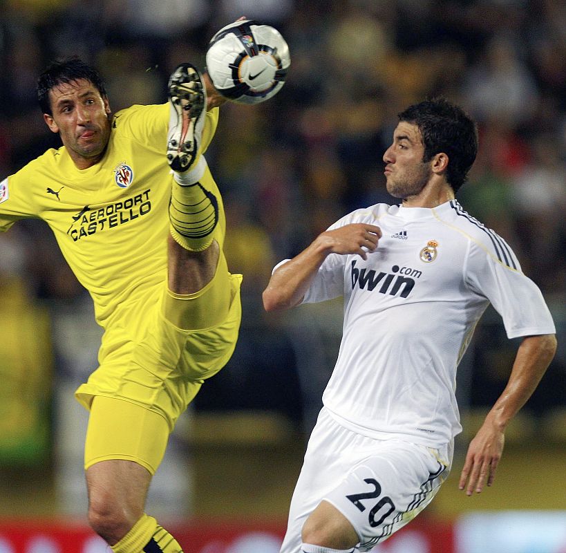 El delantero argentino del Madrid, Gonzalo Higuaín pelea un balón con el defensa amarillo Joan Capdevila.