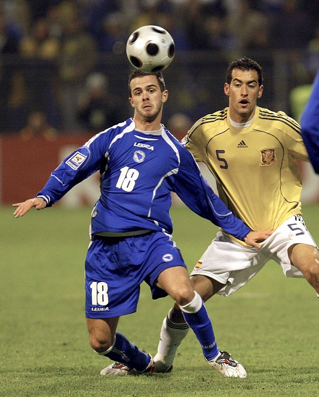 El defensa de la selección española Sergio Busquets pelea por el control del balón con el jugador de Bosnia Herzegovina, Pjanic.